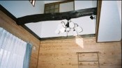 【居間】  築45年の旧建物に使用してあった 松丸太梁を再利用して居間の中央に 入れ、照明器具も合わせてみました。